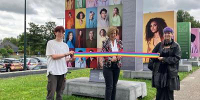 Wethouder knipt door een regenboog lint en opent officieel de tentoonstelling 